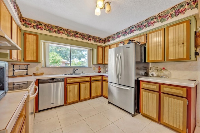 1115 Lake Francis Dr, Apopka, FL 32712 - kitchen with stainless steel appliances, a sink, light countertops, a textured ceiling, and backsplash