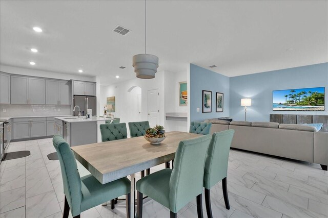 9239 Sommerset Hills Dr, Davenport, FL 33896 - dining space with light marble finish flooring, arched walkways, and recessed lighting