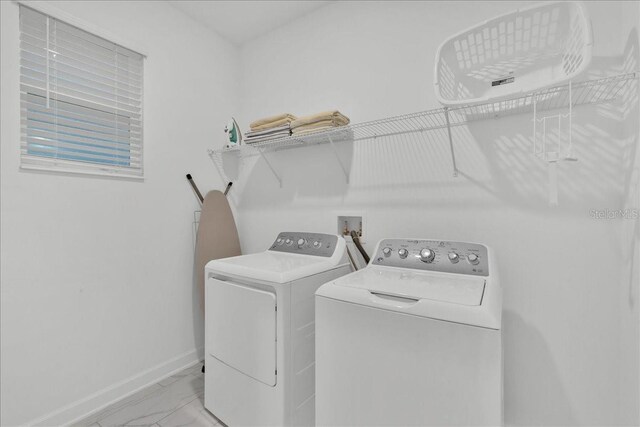 9239 Sommerset Hills Dr, Davenport, FL 33896 - laundry room with independent washer and dryer, light marble finish floors, and baseboards