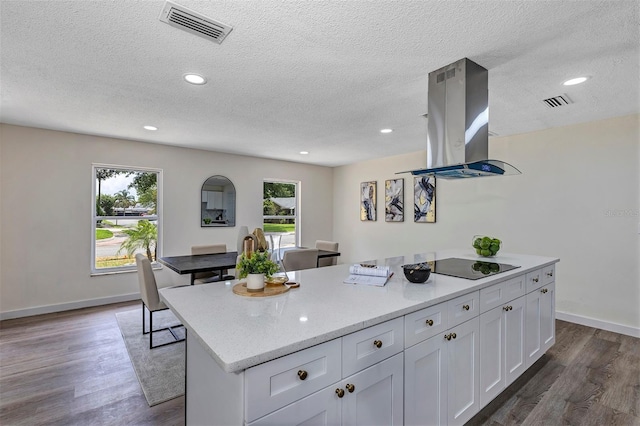 822 Glen Arden Way, Altamonte Springs, FL 32701 - kitchen with island exhaust hood, white cabinetry, a textured ceiling, dark wood-style flooring, and baseboards