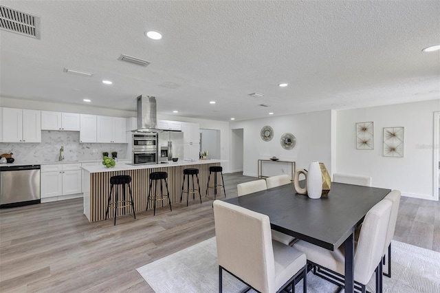 822 Glen Arden Way, Altamonte Springs, FL 32701 - dining room featuring a textured ceiling, light wood-style flooring, and recessed lighting