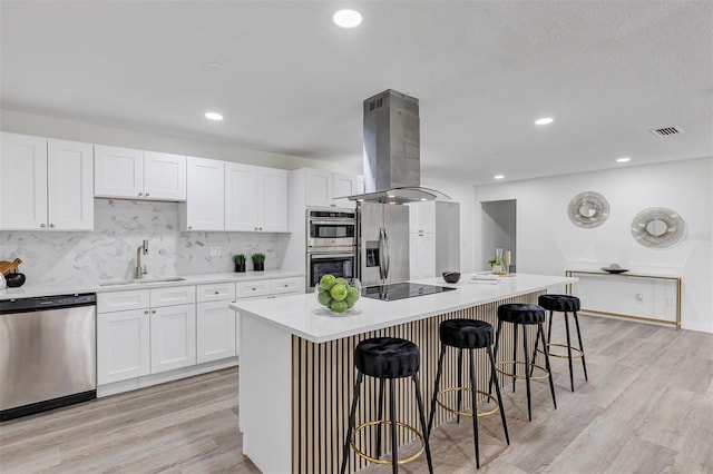 822 Glen Arden Way, Altamonte Springs, FL 32701 - kitchen featuring appliances with stainless steel finishes, island exhaust hood, a kitchen breakfast bar, white cabinetry, and recessed lighting