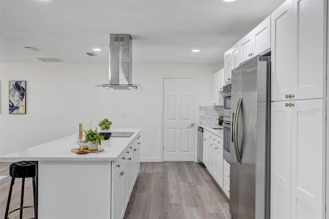 822 Glen Arden Way, Altamonte Springs, FL 32701 - kitchen with stainless steel appliances, wall chimney exhaust hood, wood finished floors, light countertops, and a breakfast bar area