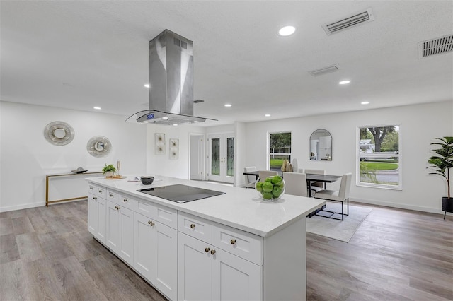 822 Glen Arden Way, Altamonte Springs, FL 32701 - kitchen featuring island exhaust hood, black electric stovetop, a center island, white cabinetry, and light countertops