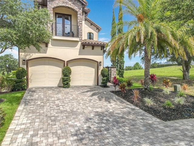 16246 Ravenna Ct, Montverde, FL 34756 - view of front of house featuring a balcony, stucco siding, decorative driveway, a garage, and a front yard