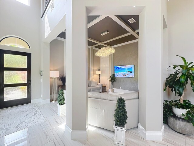 16246 Ravenna Ct, Montverde, FL 34756 - entrance foyer featuring baseboards, coffered ceiling, a chandelier, light marble finish flooring, and a towering ceiling