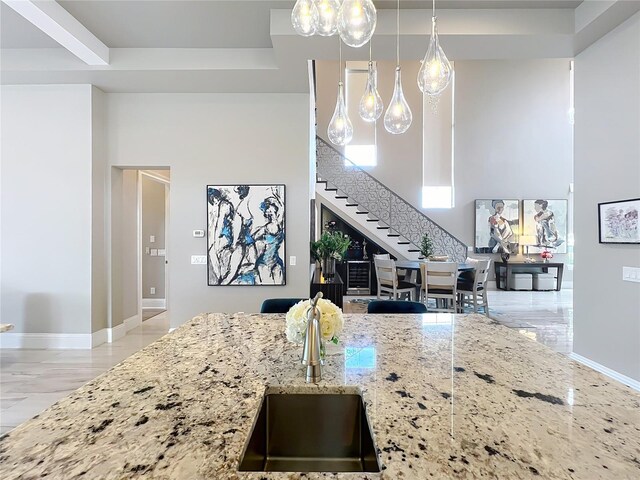 16246 Ravenna Ct, Montverde, FL 34756 - kitchen with a sink, light stone countertops, baseboards, and pendant lighting