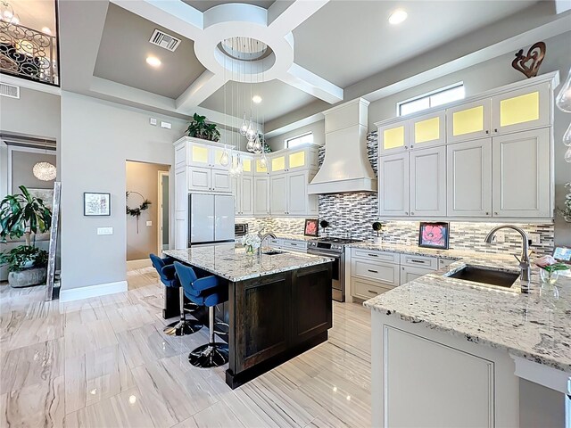 16246 Ravenna Ct, Montverde, FL 34756 - kitchen featuring stainless steel range, a sink, coffered ceiling, premium range hood, and a breakfast bar