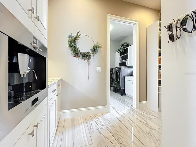 16246 Ravenna Ct, Montverde, FL 34756 - kitchen featuring separate washer and dryer, white cabinets, and baseboards