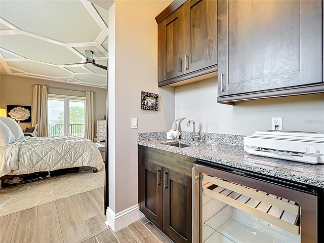 16246 Ravenna Ct, Montverde, FL 34756 - kitchen with wine cooler, a sink, a ceiling fan, open floor plan, and light stone countertops