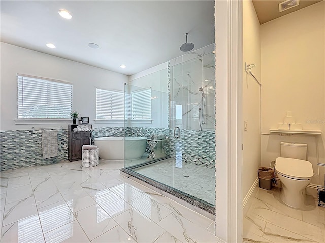 16246 Ravenna Ct, Montverde, FL 34756 - bathroom featuring marble finish flooring, a shower stall, a freestanding tub, toilet, and recessed lighting