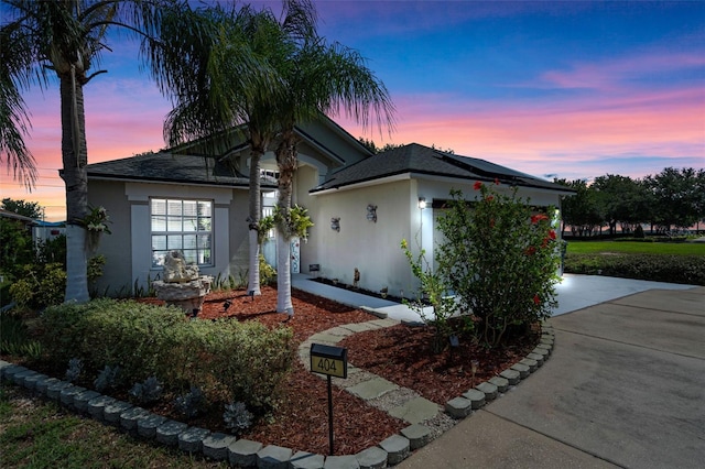 404 Obo Dr, Davenport, FL 33896 - ranch-style home with stucco siding, driveway, solar panels, and roof with shingles