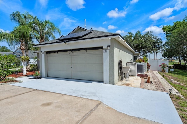 404 Obo Dr, Davenport, FL 33896 - garage with solar panels, driveway, and central AC unit