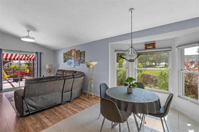 404 Obo Dr, Davenport, FL 33896 - dining room with plenty of natural light, lofted ceiling, a textured ceiling, tile patterned flooring, and baseboards