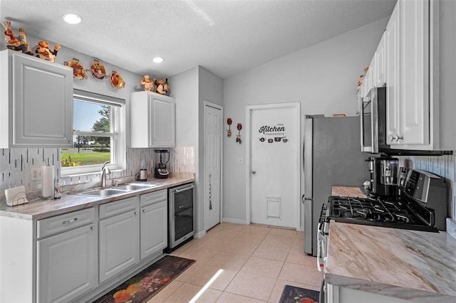 404 Obo Dr, Davenport, FL 33896 - kitchen featuring a sink, wine cooler, stainless steel appliances, light countertops, and white cabinets