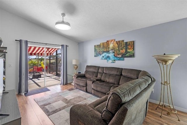 404 Obo Dr, Davenport, FL 33896 - living room with lofted ceiling, wood finished floors, and a textured ceiling