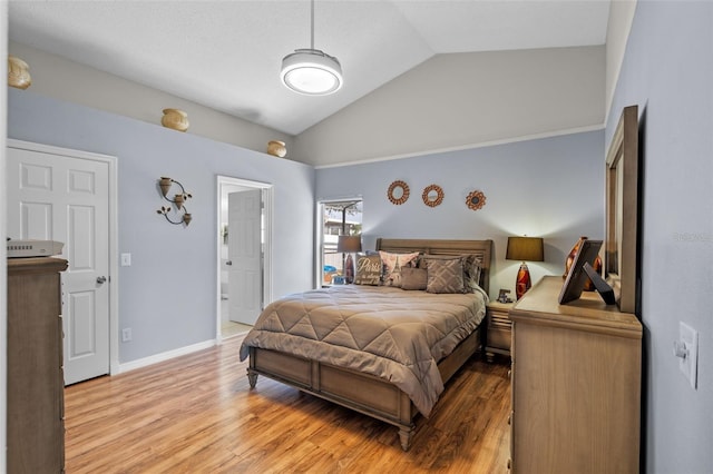 404 Obo Dr, Davenport, FL 33896 - bedroom with vaulted ceiling, light wood finished floors, baseboards, and ensuite bath