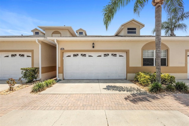 17404 Chateau Pine Way, Clermont, FL 34711 - view of front of property with decorative driveway, stucco siding, and a garage