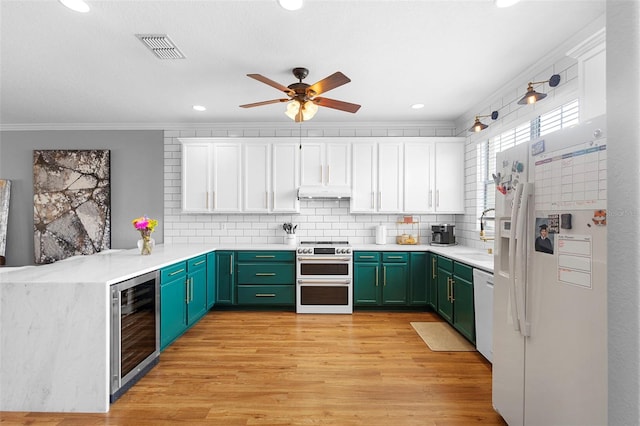 17404 Chateau Pine Way, Clermont, FL 34711 - kitchen featuring white appliances, wine cooler, under cabinet range hood, green cabinets, and ornamental molding
