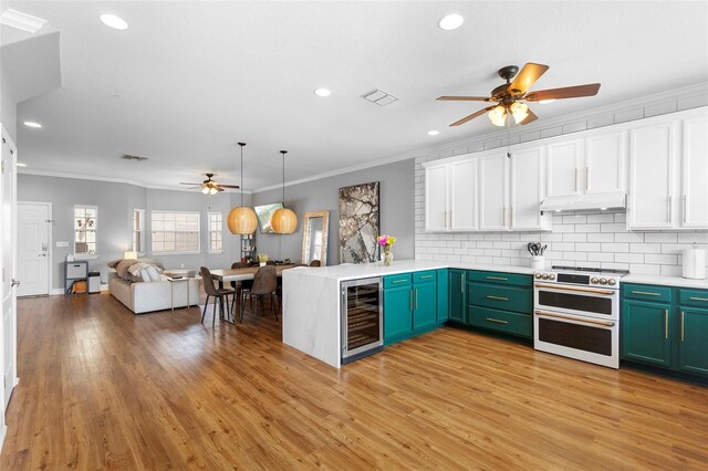 17404 Chateau Pine Way, Clermont, FL 34711 - kitchen with ceiling fan, double oven range, beverage cooler, under cabinet range hood, and ornamental molding