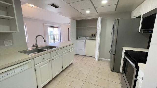 kitchen with stainless steel appliances, a sink, open shelves, washing machine and dryer, and recessed lighting