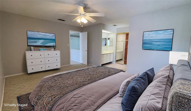 bedroom with light carpet, baseboards, ensuite bathroom, and ceiling fan