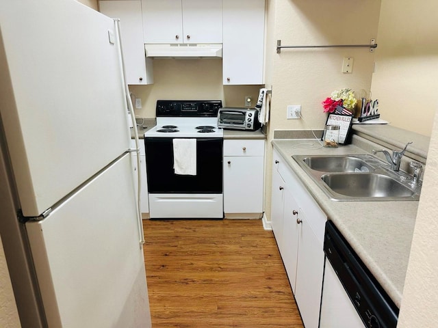 kitchen featuring freestanding refrigerator, range with electric stovetop, dishwasher, under cabinet range hood, and a sink