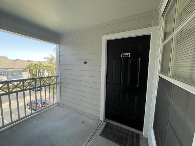 view of exterior entry featuring a balcony