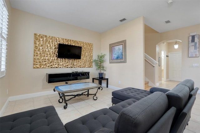 3938 Calabria Ave, Davenport, FL 33897 - living area with arched walkways, tile patterned floors, stairway, and baseboards