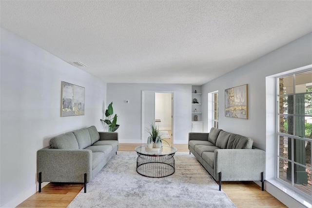 140 Sweet Bay Cir, Lake Mary, FL 32746 - living area with light wood-style floors, a textured ceiling, built in features, and baseboards