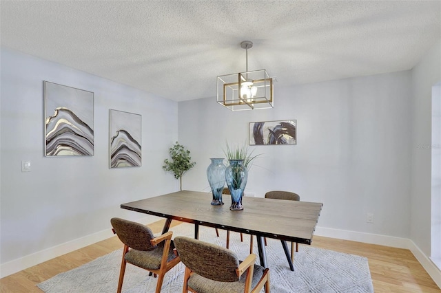 140 Sweet Bay Cir, Lake Mary, FL 32746 - dining room featuring a chandelier, light wood-style flooring, baseboards, and a textured ceiling