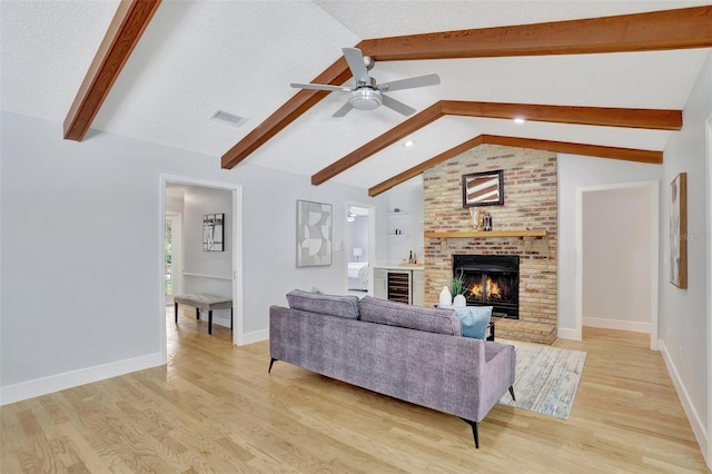 140 Sweet Bay Cir, Lake Mary, FL 32746 - living area with light wood-style floors, a ceiling fan, a brick fireplace, baseboards, and a textured ceiling