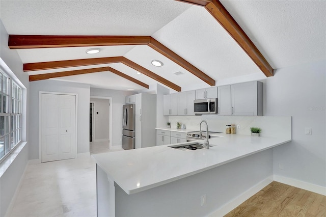 140 Sweet Bay Cir, Lake Mary, FL 32746 - kitchen featuring stainless steel appliances, light countertops, a peninsula, gray cabinets, and a sink