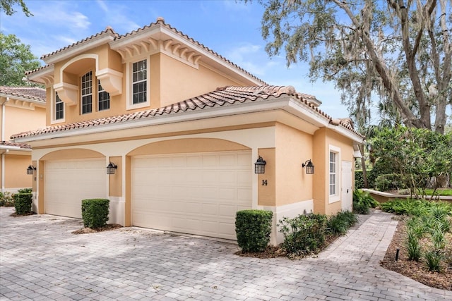 14 Camino Real Blvd Unit 14, Howey In The Hills, FL 34737 - mediterranean / spanish-style home with stucco siding, a garage, decorative driveway, and a tiled roof