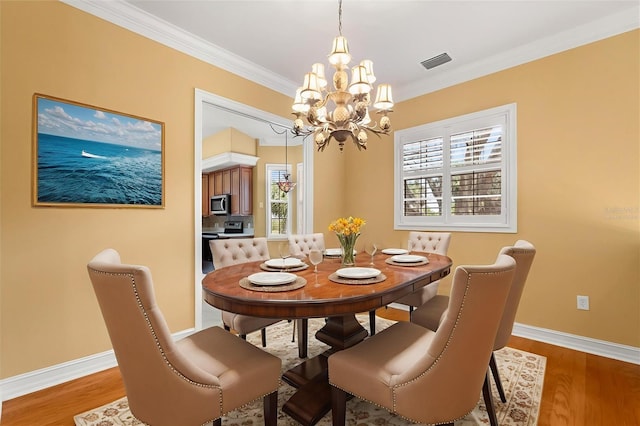 14 Camino Real Blvd Unit 14, Howey In The Hills, FL 34737 - dining space featuring a chandelier, wood finished floors, baseboards, and crown molding