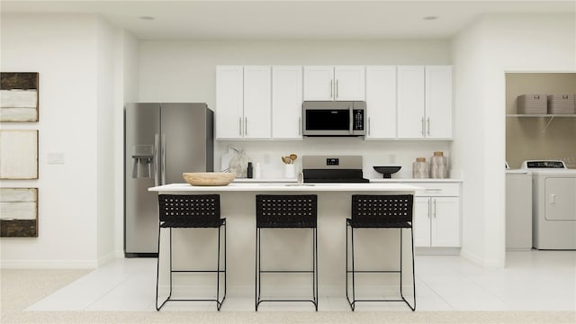 2227 Chris Dr, Winter Haven, FL 33884 - kitchen with stainless steel fridge, washing machine and clothes dryer, range, a kitchen bar, and white cabinetry