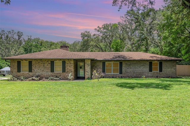 7205 June Bug Ln, Orlando, FL 32818 - ranch-style house with a chimney, brick siding, a yard, and roof with shingles