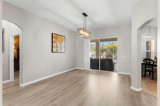 2359 Baronsmede Ct, Winter Garden, FL 34787 - unfurnished dining area featuring arched walkways, light wood-type flooring, and baseboards