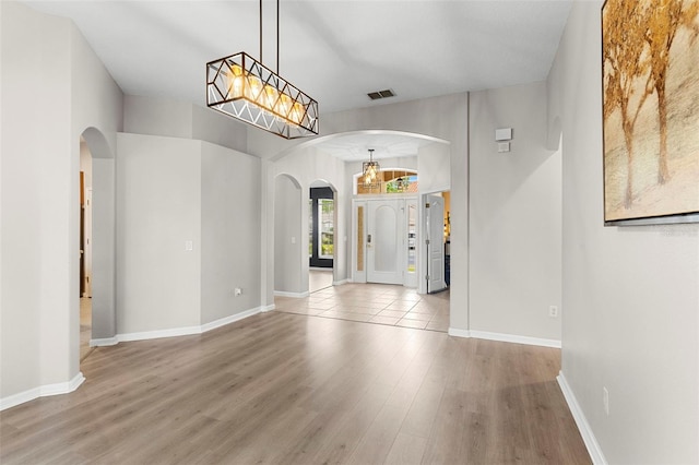 2359 Baronsmede Ct, Winter Garden, FL 34787 - entryway with arched walkways, wood finished floors, baseboards, and a chandelier