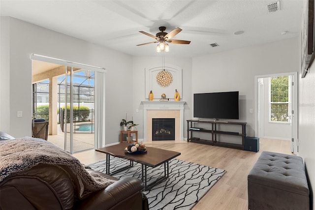 2359 Baronsmede Ct, Winter Garden, FL 34787 - living area with a ceiling fan, light wood finished floors, and a glass covered fireplace
