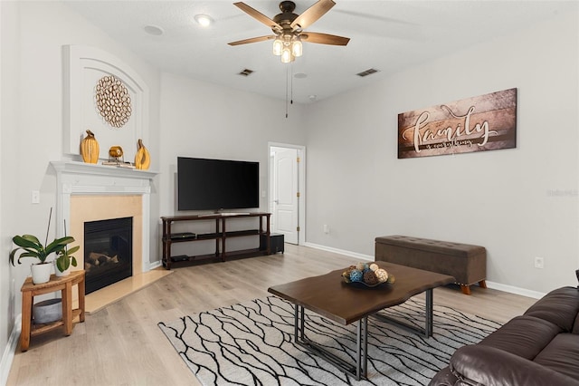 2359 Baronsmede Ct, Winter Garden, FL 34787 - living room featuring a ceiling fan, light wood finished floors, a glass covered fireplace, and baseboards