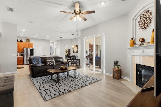2359 Baronsmede Ct, Winter Garden, FL 34787 - living room with light wood-style floors, a ceiling fan, a high end fireplace, recessed lighting, and baseboards