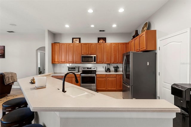 2359 Baronsmede Ct, Winter Garden, FL 34787 - kitchen with stainless steel appliances, a sink, recessed lighting, a kitchen breakfast bar, and arched walkways