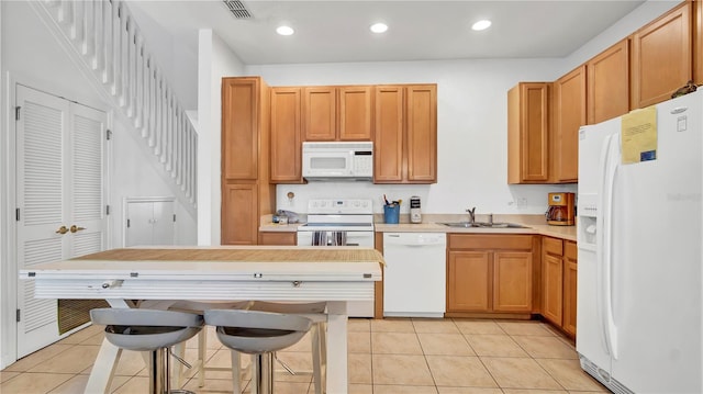 2343 Caravelle Cir, Kissimmee, FL 34746 - kitchen with white appliances, a sink, light tile patterned flooring, light countertops, and recessed lighting