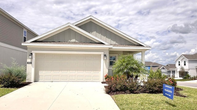 2002 Punch Bowl Ave, Davenport, FL 33837 - view of front facade with board and batten siding, driveway, and an attached garage