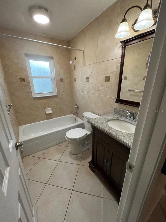 7011 Archwood Dr, Orlando, FL 32819 - bathroom featuring tile patterned floors, tile walls,  shower combination, vanity, and toilet