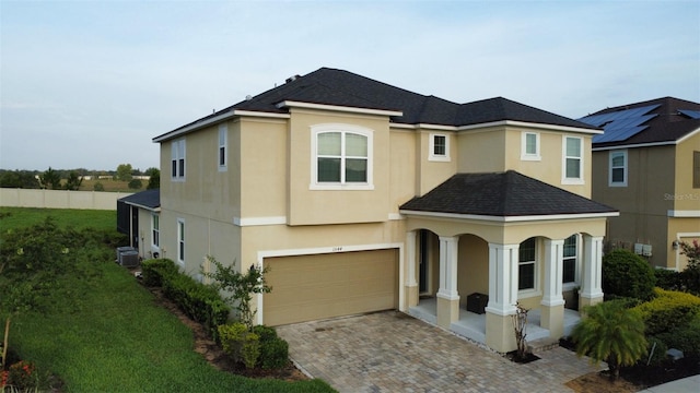 1544 Nassau Point Trl, Kissimmee, FL 34747 - view of front of house featuring stucco siding, an attached garage, decorative driveway, central air condition unit, and roof with shingles