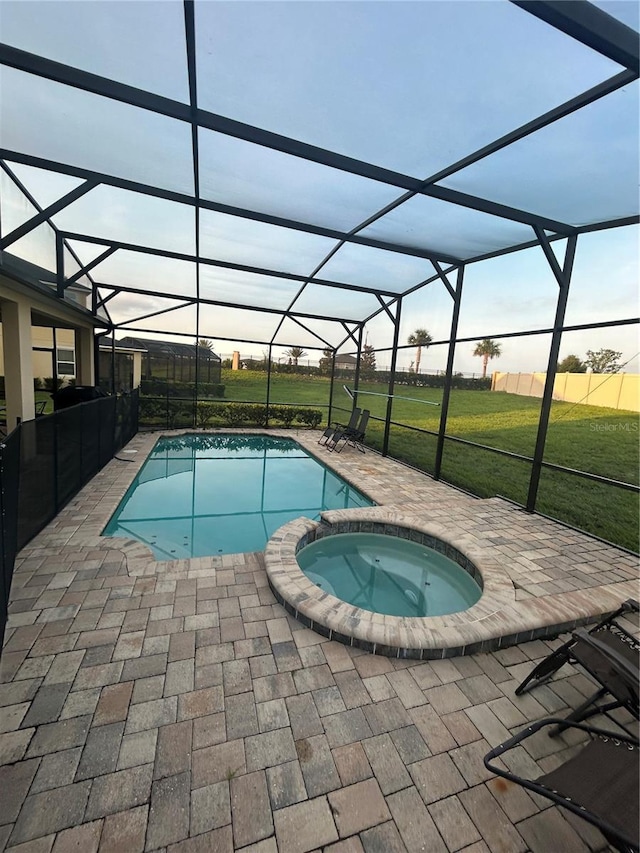 1544 Nassau Point Trl, Kissimmee, FL 34747 - view of pool featuring glass enclosure, a patio area, a pool with connected hot tub, and a lawn