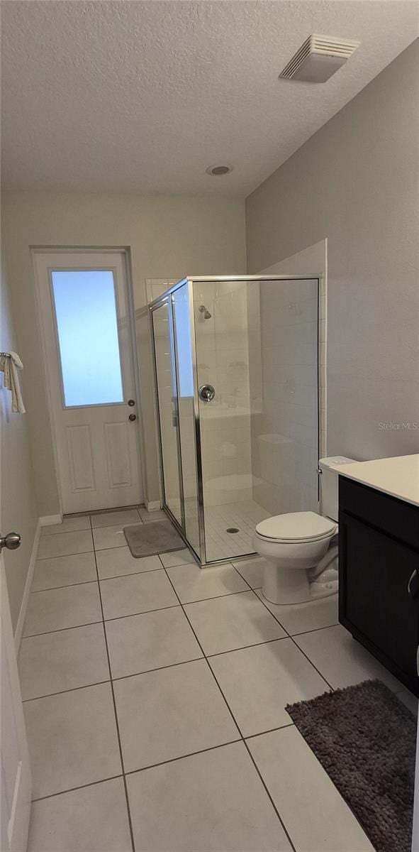 1544 Nassau Point Trl, Kissimmee, FL 34747 - full bath with a stall shower, vanity, a textured ceiling, tile patterned flooring, and toilet