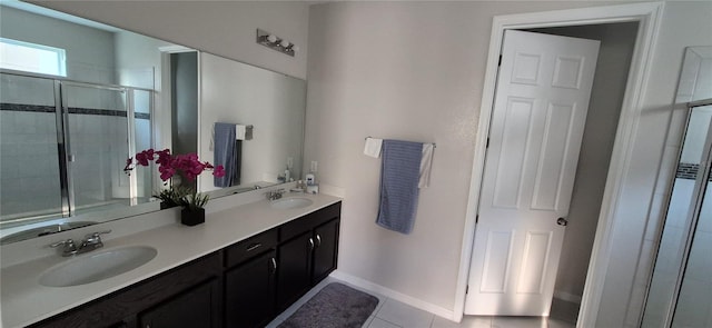 1544 Nassau Point Trl, Kissimmee, FL 34747 - bathroom featuring double vanity, tiled shower, tile patterned flooring, and baseboards